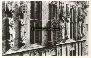 F001367 Beelden en laat-gotische ijzeren kooi aan de gevel van het Oude Raadhuis aan de Oudestraat, v.l.n.r. Karel de ...