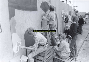 F005729 Beschildering van een omheining rond Buitenkade 2 en 4 door schoolleerlingen.