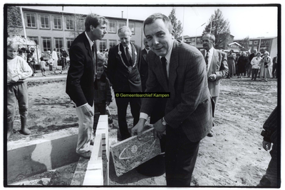 F006686 A. Tuitel, voorzitter van woningbouwvereniging Kampen, met de eerst steenvoro het complex van 28 koop- en 64 ...