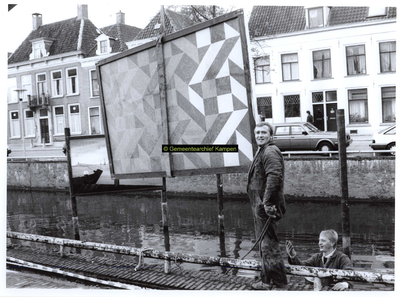 F004801 Verwijdering van aan de Burgwal geplaatste schilderijen van de StichtingPromotie Kampen door medewerkers van de ...