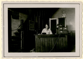 F010283 Leeszaal in het Gotische huis, met vrouw achter bureau.Op 9 februari 1921 is de openbare leeszaal geopend.De ...