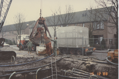 F015298 IJsselmuiden, Het plaatsen van een pompput in de Hoepelweg in december 1988.