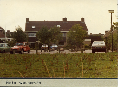 Blok woonhuizen met geparkeerde auto's. Auto rechts heeft kenteken 11-RP-07