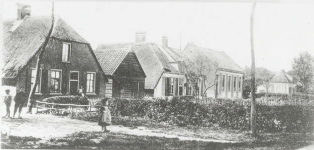  Woningen met rieten daken, een houten schuur en spelende kinderen, uiterst rechts de openbare school