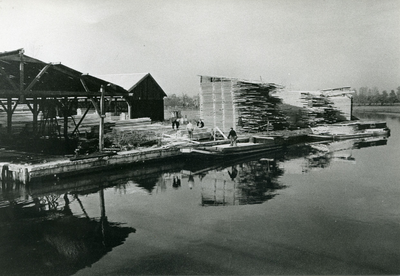  Opslagloodsen op het terrein van Houthandel Van Dam met steiger aan de Kromme Rijn waar hout wordt aangevoerd.