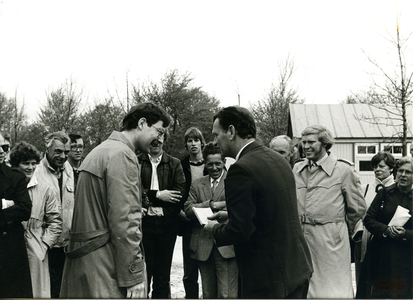  Wethouder drs. C.M. de Vos (midden met bril) in gesprek tijdens de eerste steenlegging van de sporthal.