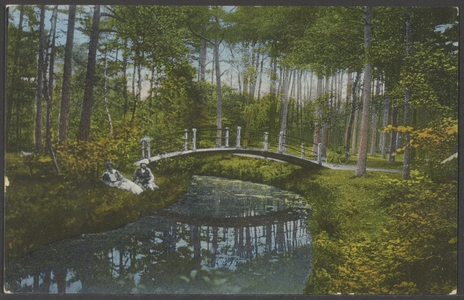  Brug over beekje in het bos, links twee dames zittend aan de oever van de beek.