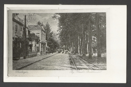  De Hoofdstraat, rechts de tramrails en een rij bomen. Geheel links Kraal's Boek- en Kunsthandel.