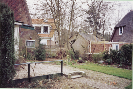  Zijkant huis met oprit en nieuwbouw bij buren.