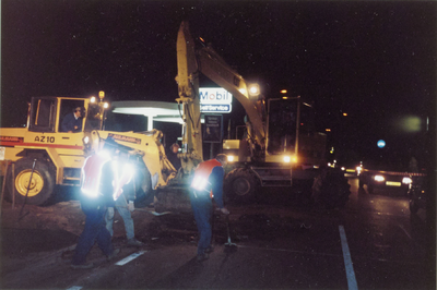  Nachtfoto met werklui en auto's aan de Hoofdstraat?