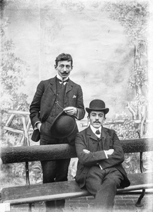  portret van 2 mannen staand en zittend op bank