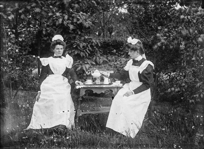  portret twee vrouwen met theeservies in de tuin