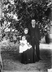  familieportret man, vrouw en kind in de tuin