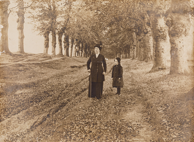  Foto van H. (Mien) Smits-van Wijngaarden met een meisje in een laan bomen waarschijnlijk te Rhenen