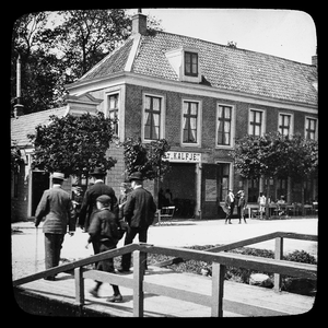  Drie mannen en een jongen, op de rug gezien, wandelend naar Het Kalfje aan de Amstel in Amstelveen