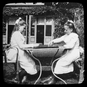  Twee meisjes met een bordspel in de tuin: ‘Pension Trompenberg’