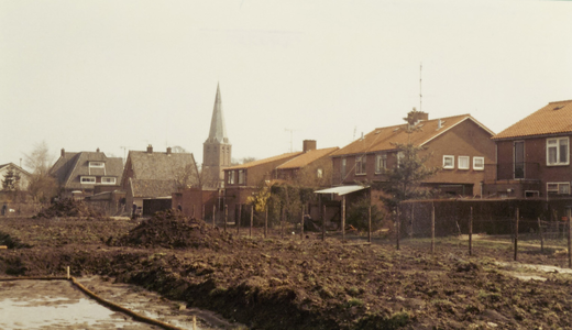  Bouwterrein achter de Cotherweg Z-N. met zicht op huizen en de kerktoren.