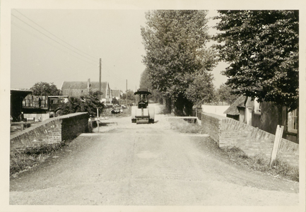  Een wals ter verbetering van de weg bij de Stenen Brug. Links staat een bord 'GESTREMD'.