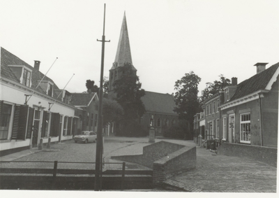  Links het gemeentehuis, rechts de brug en in het midden de N.H. kerk.