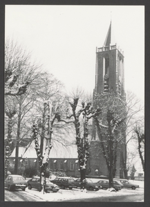  De toren van de St. Andrieskerk in de sneeuw gezien vanaf de Hof met geparkeerde auto's.