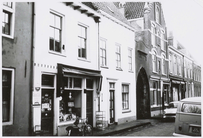  De kruidenier op nr 5 links, rechts Volkswagenbus UV 77-71. Nr. 7 was tot 1923 in gebruik als synagoge. De poort ...