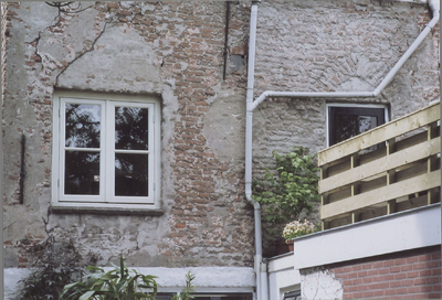  Zicht op de achterkant tijdens een verbouwing; een raam met spitsboogmetselwerk.