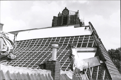  Het dak van het woonhuis tijdens de restauratie met regels voor de dakpannen. Erbovenuit steekt de kerktoren van de ...
