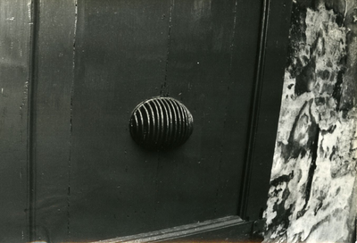  Een ovale versiering van halfronde metalen boogjes onderaan een deur, waarschijnlijk die van het voormalige zusterhuis.
