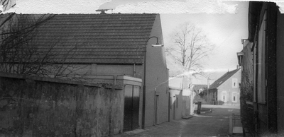  Gezicht richting Singel met links een pakhuis met pannenzadeldak. Daarvoor een lager deel met plat dak en garagedeuren ...