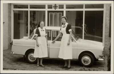  De zusters Smit en van Rooijen bij de eerste auto van het Groene Kruis, een Daffodil.