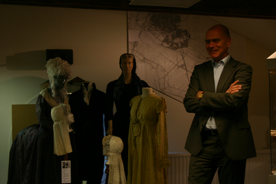  Wethouder van Dalen bij enkele kledingstukken tijdens de tentoonstelling over Wickenburgh in het archeologiemuseum
