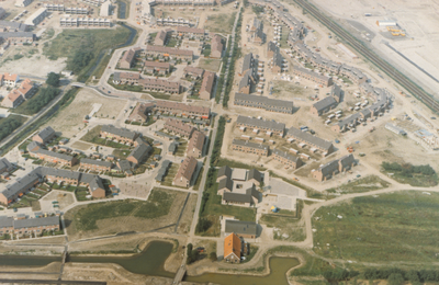  Luchtfoto van een gedeelte van de wijk de Hoeven tijdens de bouw met de Lobbendijk in het midden