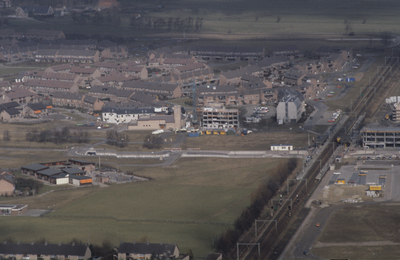  Luchtfoto van de wijk de Hoeven met links basisschool De Regenboog en in het midden de Opstandingskerk