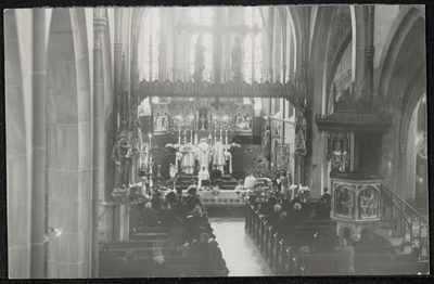  Het interieur van de rooms-katholieke kerk tijdens een mis 'met drie heren' gezien vanaf het koor