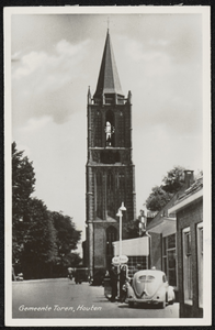  De toren van de Nederlandse-hervormde kerk met rechts een VW-kever bij de Esso-benzinepomp van garage De Vico