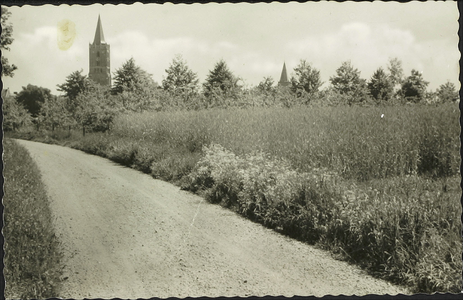  Landschap bij Houten met op de achtergrond de torens van de nederlands-hervormde kerk en rooms-katholieke kerk. De weg ...