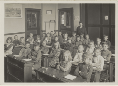  Klaslokaal met kinderen en onderwijzeres in de openbare lagere school ''t Groentje.