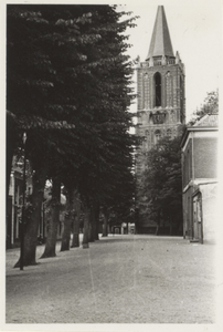  Gezicht op de Nederlands-hervormde kerktoren met op de voorgrond de bomenrij aan de westzijde van het Plein en rechts ...