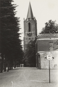  Gezicht op de Nederlands-hervormde kerktoren met op de voorgrond de bomenrij aan de westzijde van het Plein en rechts ...