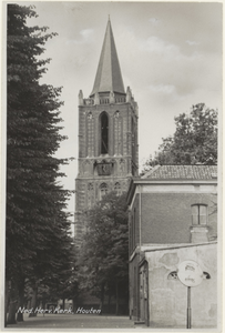  Gezicht op de nederlands-hervormde kerktoren met op de voorgrond de bomenrij aan de westzijde van het Plein en rechts ...