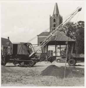  Graafmachine bezig met de aanleg van de riolering. Op de achtergrond de muziektent.