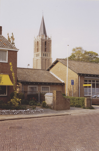  Gedeelte van de voorgevel van de Prins Bernhardschool met daarachter de toren van de nederlands-hervormde kerk.