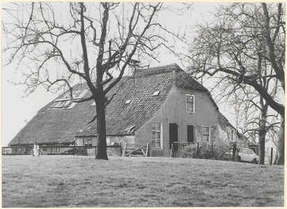 Boerderij Blokhoven. Gezicht op de voorgevel en linkerzijgevel van de boerderij met op de voorgrond hoogstam-fruitbomen.