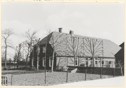  De voorgevel en rechter zijgevel van de boerderij met leilinden.