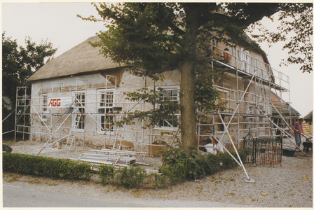  De ontpleisterde voorgevel en rechterzijgevel van het voorhuis van de boerderij tijdens de restauratie.