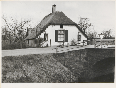  Gezicht op de voorgevel en linkerzijgevel met op de voorgrond de Provincialeweg en een brug naar het Overeind. Deze ...