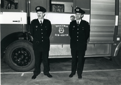  Twee brandweermannen poseren voor de brandweerauto van Schalkwijk.