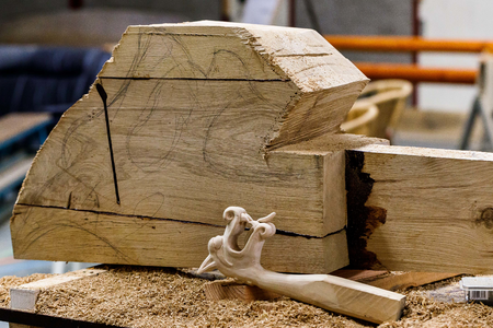  Miniatuur drakenkop naast het blok hout waar de uiteindelijke drakenkop van gemaakt wordt.