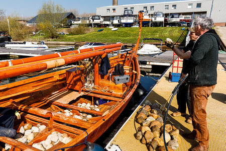  Plaatsen van 1500 kg rivierkeien als ballast; L>R Michiel Otsen, Ruud Waltman