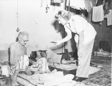 Nurse T. Jongsma with a patient in the cloister-turned-hospital Mater Dolorosa in Batavia, 1945.&lt;br/&gt;NIOD 53831 &lt;a class=uline href=http://www.beeldbankwo2.nl target=_blank&gt;Beeldbank WO2&lt;/a&gt;